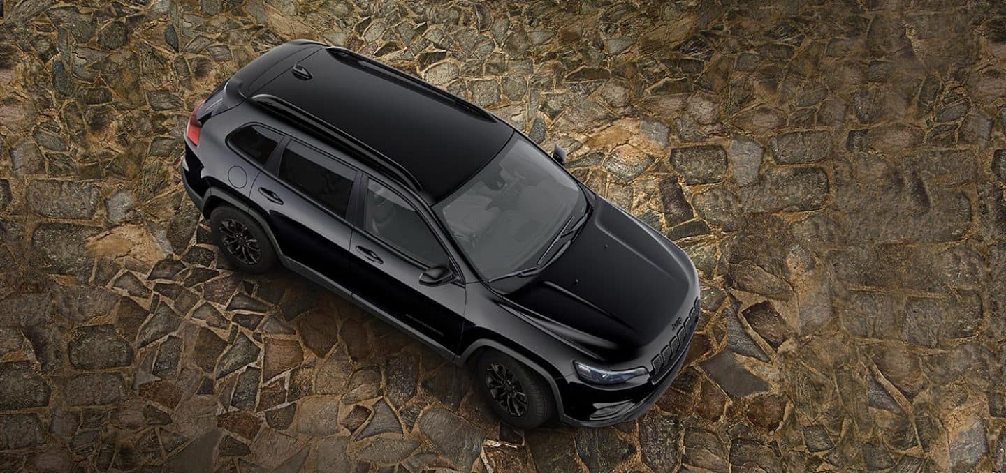 Display An overhead view of a 2023 Jeep Cherokee Altitude Lux parked on a cobblestone surface.